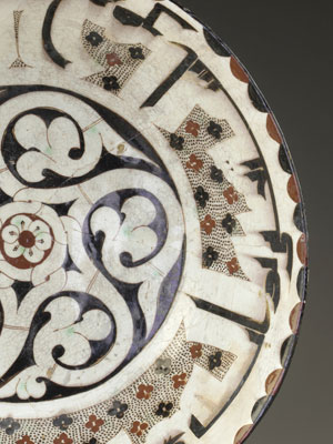 Ceramic bowl decorated with floral patterns and calligraphy in enamel.