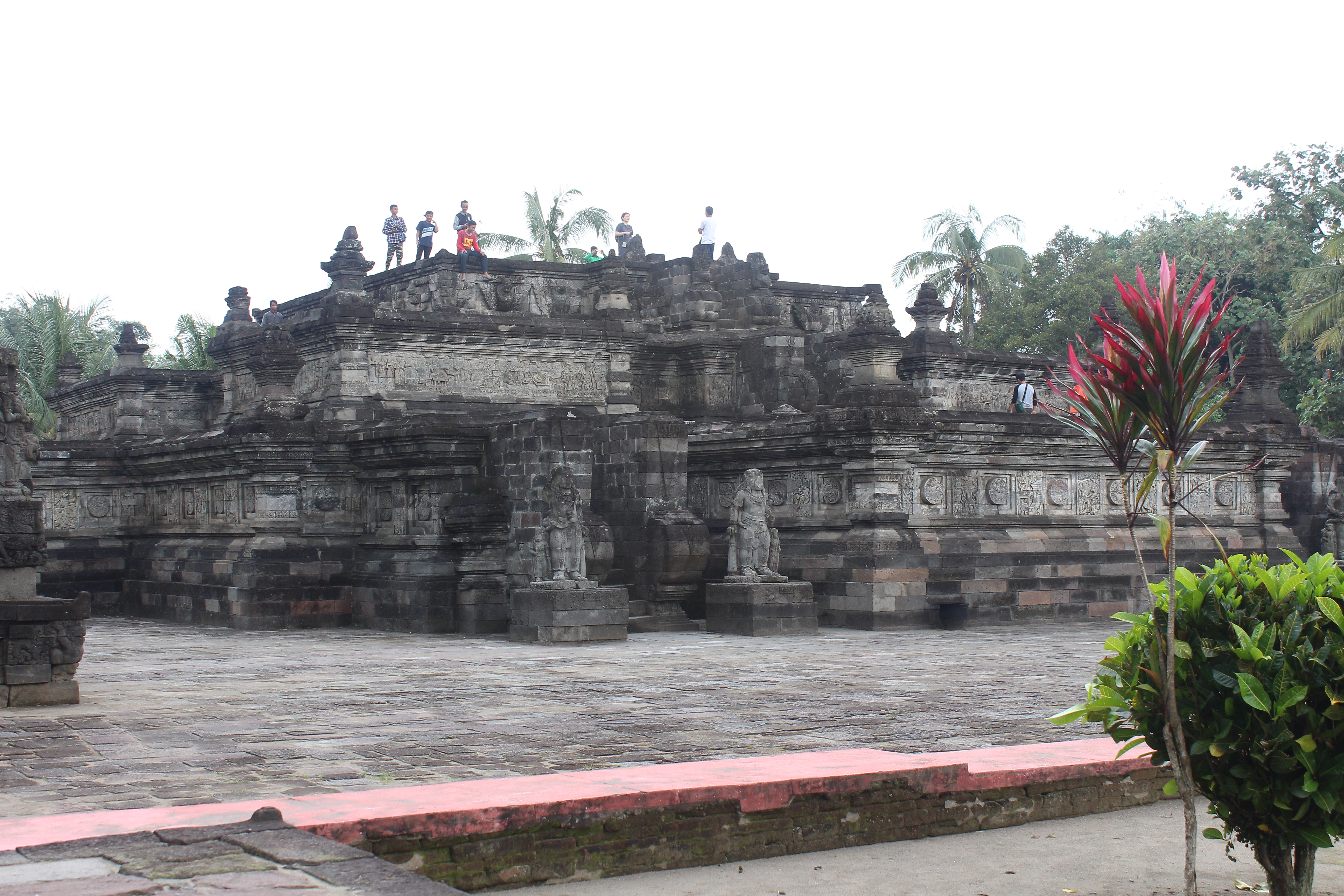 Large stone temple complex with relief carvings in a monumentified area