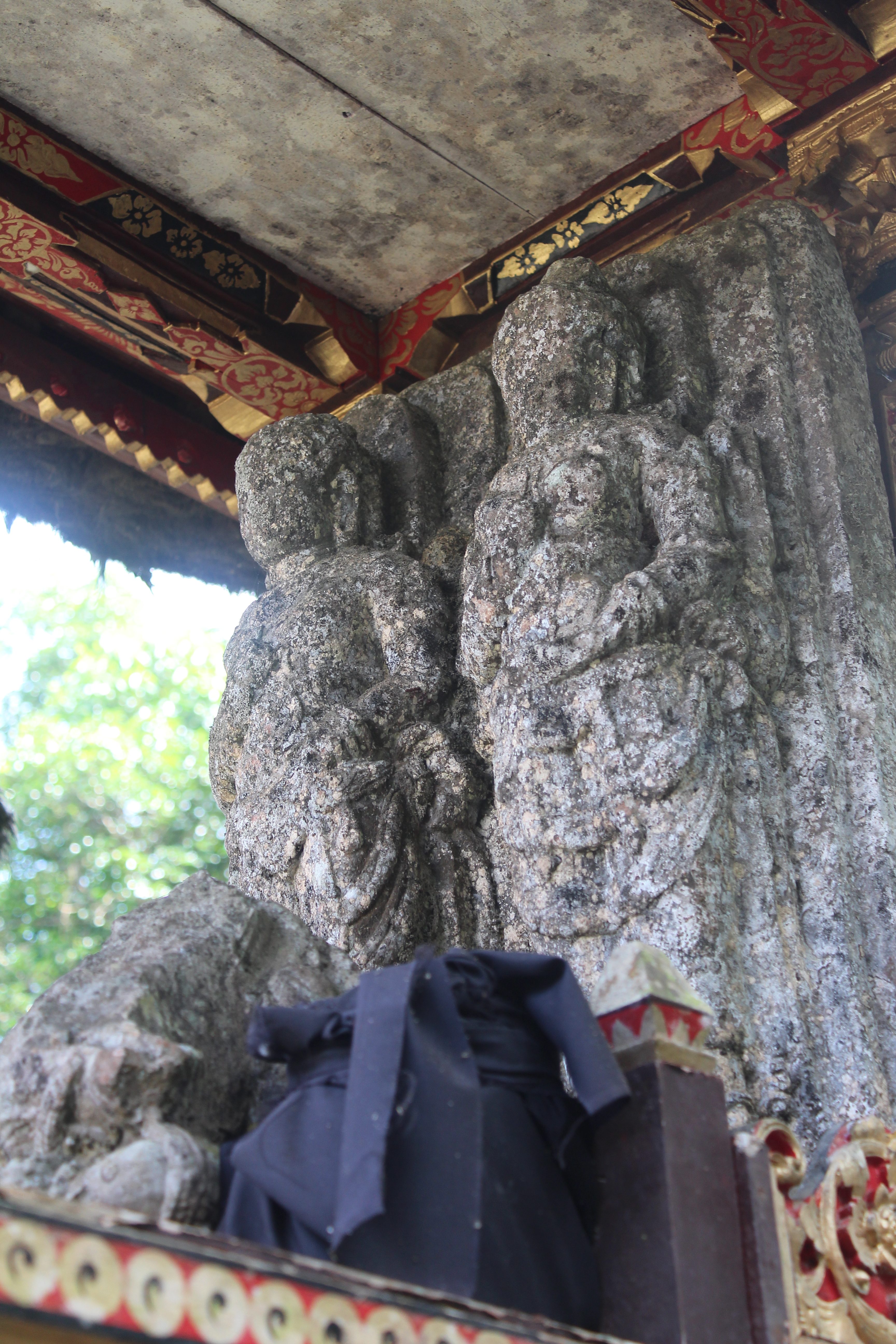 Pair of weathered figural sculptures in a tall shrine